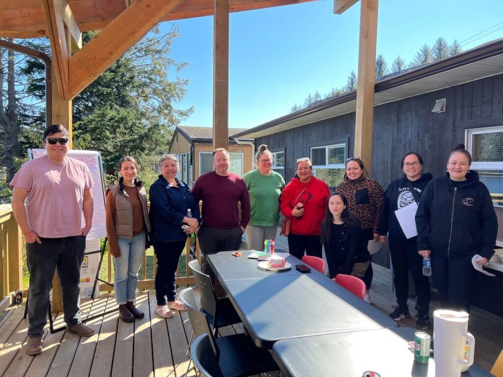 A group photo of Treehouse staff & students with the WAYK Team on the deck behind the building in Port Hardy, BC. Incoming students joined the current Treehouse students for an orientation lunch in Spring 2025. 